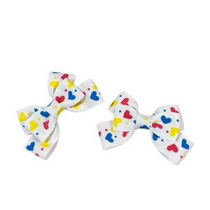 Set of 2 white bow hair clips with colorful heart patterns for girls and princesses