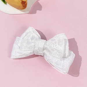 Elegant white lace floral bow hair clip for women with delicate embroidery on pink background