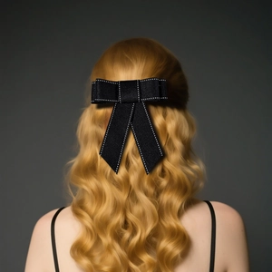Elegante zwarte strik haarspeld met witte stiksels op lang blond golvend haar