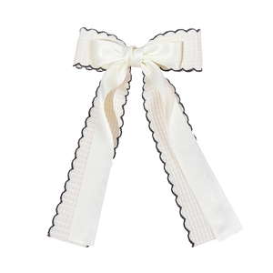Elegant off-white double layer bow hair clip with black wavy scalloped edges and long ribbons