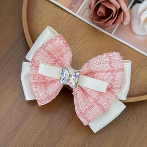 Barrette à nœud en tweed rose et satin avec papillon en strass sur plateau en bois