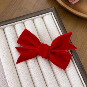 Elegant red velvet ribbon bow hair clip for women with a vintage aesthetic look