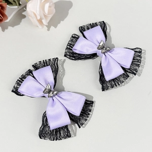 Detail of lavender satin bow hair clips with black lace trim and silver butterfly accents