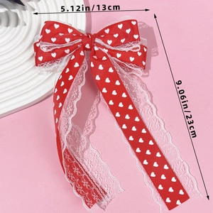 Vue détaillée du nœud papillon rouge avec motifs cœurs et dentelle, dimensions 13cm sur 23cm