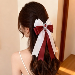 Detail of red and white bow hair clip with vintage silver pendant and ruby crystal on hair