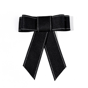 Detail van zwarte denim strik met witte contraststiksels en specifieke strikdetails