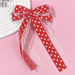 Détail du nœud de cheveux avec imprimé cœur rouge et bordure en dentelle blanche