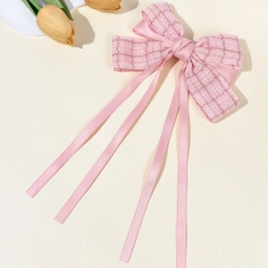 Elegant pink tweed bow hair clip with long ribbons and a stylish chic design