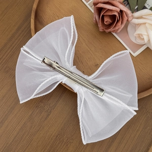 Elegante fermaglio per capelli con fiocco in organza bianca su vassoio di legno