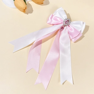 Detail of multi-layered bow hairpin with heart gemstone and elegant satin ribbons