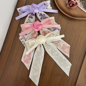 Elegant embroidered ribbon hair clips with satin roses in purple, pink, and cream white