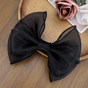 Vista dettagliata di un grande fermaglio per capelli a fiocco in organza nera mesh