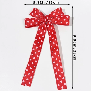 Détail d'un nœud papillon rouge de 13x23cm avec motifs cœurs et rubans longs élégants