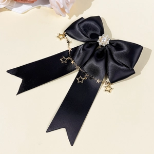 Details von schwarzer Satinschleife Haarklammer mit Perle und goldenen Sternanhängern
