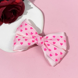 Pince à cheveux rose avec nœud et motif cœur sur fond romantique avec des roses