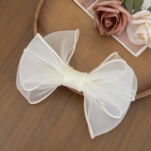 Dettaglio ravvicinato del fermaglio per capelli a fiocco in organza con bordi arrotolati