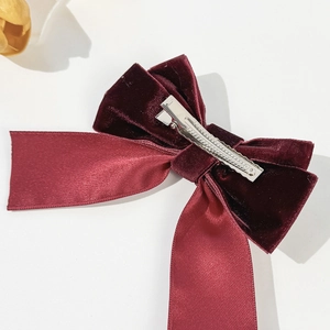 Elegant burgundy velvet and satin bow hair clip with metal alligator grip on white base