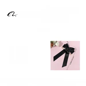 Detail of black bow hair clip with gold star chain charms and soft elegant streamers