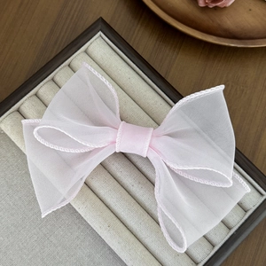Barrette élégante avec nœud en organza rose clair, texture maille délicate et design chic