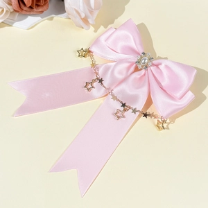 Detail von rosa Satin-Schleife mit goldenen Sternketten und Perlen-Strass-Verzierung