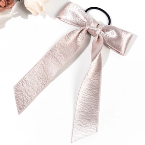 Chouchou élégant en satin or rose avec long ruban sur un fond blanc épuré