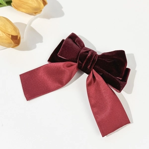 Detailed view of handmade burgundy velvet bow hair clip with elegant satin ribbons