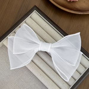 Pince à cheveux élégante en organza blanc avec tulle multicouche sur un plateau à bijoux