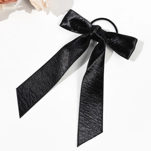 Détail d'un chouchou élégant en satin noir avec long ruban et texture soyeuse