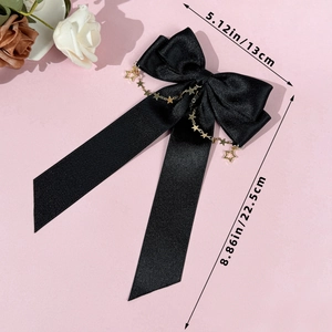 Detail of black satin bow hair clip with gold star chains and dimension markings