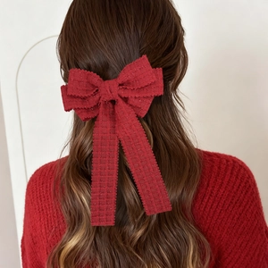 Détail d'un nœud papillon rouge en tweed avec rubans en tissu texturé pour femme