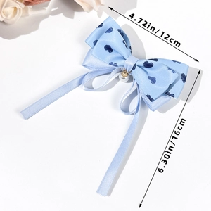 Détail du nœud papillon en satin bleu clair avec imprimé cœur, perle et dimensions