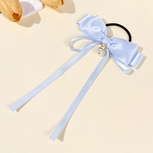 Detail of light blue satin bow hair tie with pearl pendant and long ribbon streamers