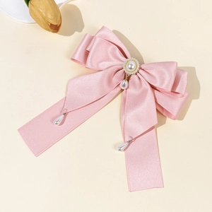 Nahaufnahme der rosa Satin-Schleife mit goldener Perle und hängenden Perlen-Anhängern