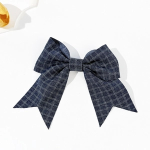Fermaglio per capelli a fiocco scozzese in blu navy e bianco su uno sfondo bianco