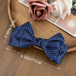 Detail view of a navy blue polka dot bow hair clip with 11cm by 6cm dimensions