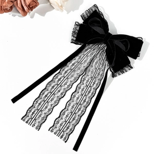 Detailed view of the black velvet bow hair clip with elegant eyelash lace tassels
