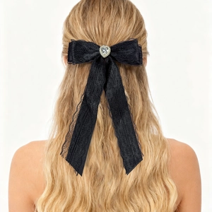 Vue détaillée du nœud en dentelle noire avec cristal de cœur sur les cheveux