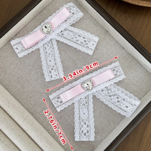 Lace bow hair clip with pink ribbon and heart rhinestone measuring 9cm by 7cm