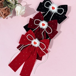 Red velvet hair bow clips with pearl chains and heart charms in a set of two