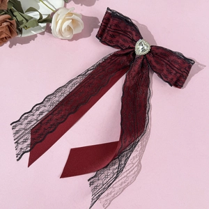 Détail du nœud papillon rouge foncé avec dentelle noire et cristal en forme de cœur