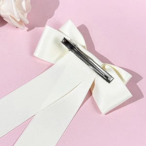 Elegante fermaglio per capelli a fiocco in raso bianco con nastri lunghi su sfondo rosa