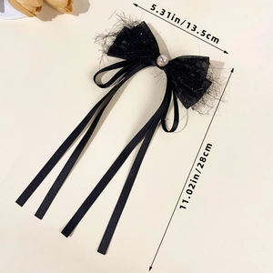 Detail view of black mesh bow hair clip with pearl bead and long tassels showing dimensions
