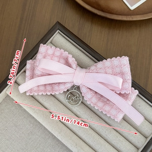 Detail of pink plaid lace bow hair clip with silver LOVE pendant in a jewelry box