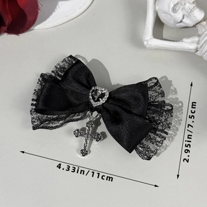 Détail d'une pince à cheveux gothique avec nœud en dentelle et pendentif croix