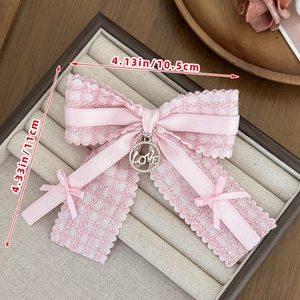 Detail of pink lace bow hair clip with gold Love pendant and ribbon dimensions 10.5x11cm