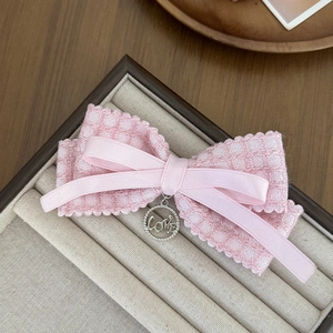 Close-up of pink lace bow hair clip with silver LOVE charm in a jewelry display box
