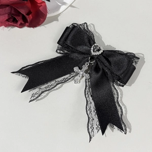 Détail de nœud gothique en satin noir et dentelle avec gemme cœur et croix argent