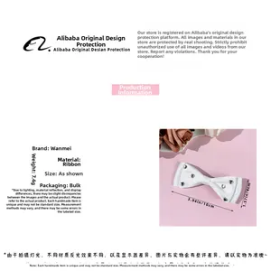 Detailed specs of white ribbon bow hair clip featuring silver heart rivets decoration