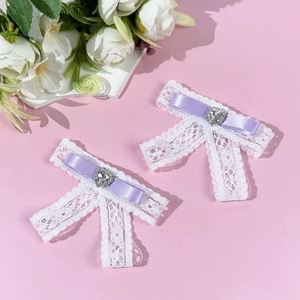 Detail of two-piece lace bow hair clips with purple ribbon and sparkling heart rhinestone