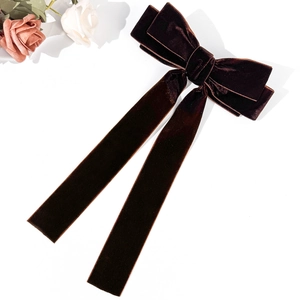 Detail view of a French vintage dark brown velvet bow hair clip with elegant long ribbons